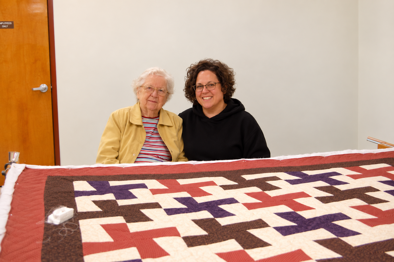 Patti Meyer with her grandmother Anna Daiber Meyer beside a quilt