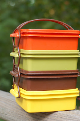 A stack of classic 1970s Tupperware in orange, green, brown, and yellow