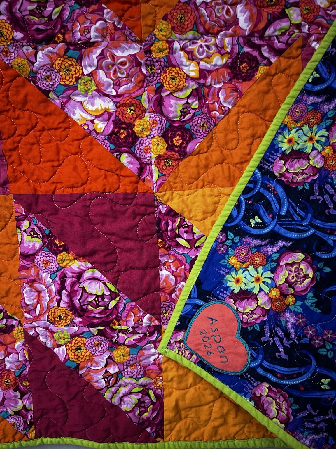 Close view of richly colored floral quilt fabrics and free-motion quilting