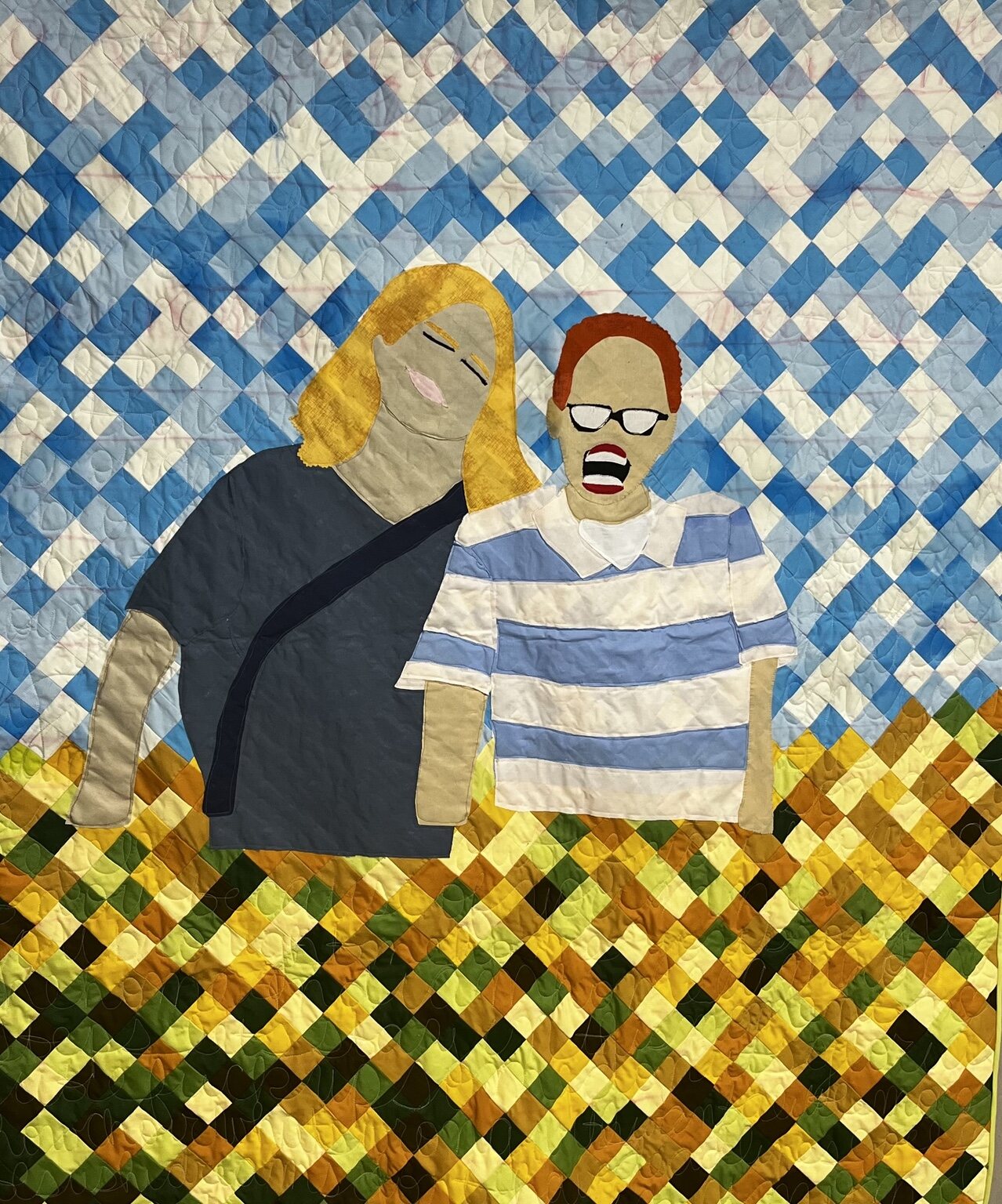 Portrait quilt with two appliquéd figures against a blue-and-white pieced background
